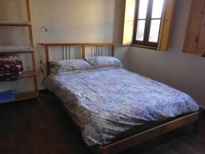 1 dormitorio con 1 cama en una habitación con ventana en Le trou dans le mur, en Uzerche