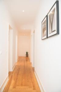 a hallway with white walls and a hard wood floor at Flattered to be in Lisboa in Lisbon