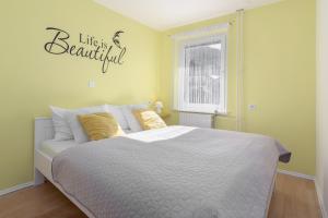 a bedroom with a bed and a sign that reads life is beautiful at Apartments Green Paradise in Bohinj