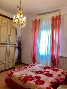 ein Schlafzimmer mit einem Bett mit roten Blumen darauf in der Unterkunft Appartamento Aurora in La Spezia