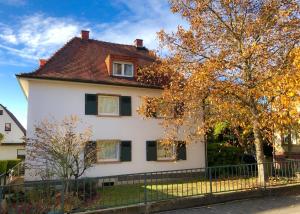 una casa blanca con ventanas negras y una valla en WeinheimResidence en Weinheim