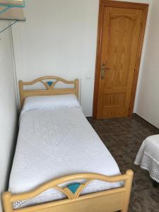 uma cama com uma estrutura de madeira num quarto com uma porta em Casa Felix em Sant Jaume d'Enveja