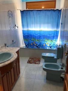 uma casa de banho com uma cortina de chuveiro de peixe e um WC. em Casa Felix em Sant Jaume d'Enveja
