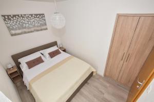 1 dormitorio con 1 cama y puerta de madera en Apartman Mia, en Igrane