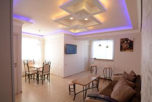 un soggiorno con divano, tavoli e sedie di Apartment a Sevan