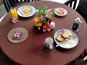 a table with plates of breakfast food and flowers on it at Gili Palms Resort in Gili Trawangan