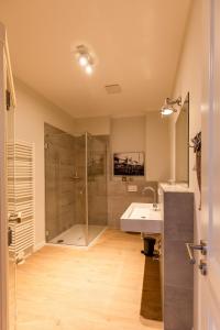 a bathroom with a shower and a sink and a tub at Dockside Travemünde in Travemünde