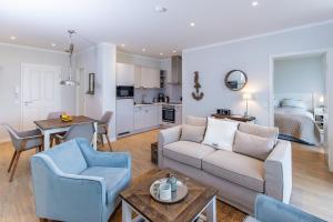 a living room with a couch and a table and a kitchen at Dockside Travemünde in Travemünde