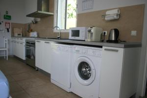 a kitchen with a washer and dryer in it at Casinha Vista Mar in Porto Santo
