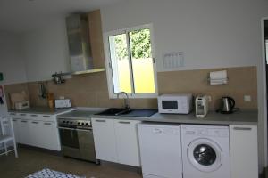 a kitchen with a sink and a washing machine at Casinha Vista Mar in Porto Santo