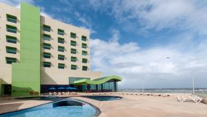 ein Hotel mit einem Pool vor einem Gebäude in der Unterkunft Holiday Inn Coatzacoalcos, an IHG Hotel in Coatzacoalcos