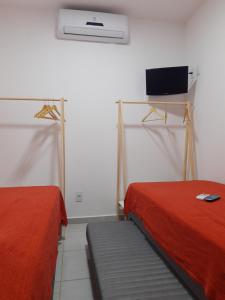 Habitación con 2 camas y TV en la pared. en Winterville Flat 708, en Gravatá