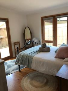 a bedroom with a large bed and a mirror at The Green Room Wattle Glen in Wattleglen