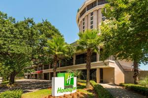 モービルにあるHoliday Inn Mobile Downtown Historic District by IHGの目の前にヒルトンの看板がある建物