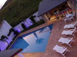 una vista aérea de una piscina con sillas y mesas blancas en Kings International Hotel, en Rio das Flores