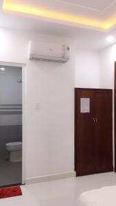 a bathroom with a toilet and a brown door at Anh Thư Hotel in Vung Tau