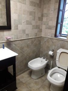 La salle de bains est pourvue de toilettes blanches et d'un lavabo. dans l'établissement CABAÑA VILLA CLUB 1 cerca del aeropuerto el Palomar, à Hurlingham
