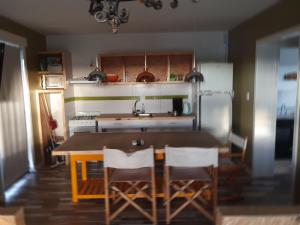 a kitchen with a table and chairs and a refrigerator at al pie de las sierras en villa del lago in Tandil