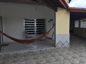 een hangmat aan de zijkant van een huis bij Casa, Praia e Lazer. in Solemar