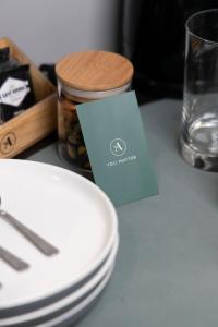 a stack of white plates and a card on a table at The Alison Randwick in Sydney