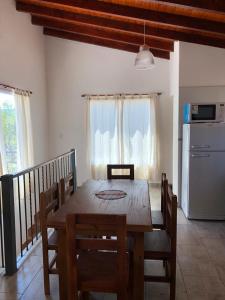 une salle à manger avec une table en bois et une cuisine dans l'établissement Cabañas Olla Vieja, à Santa Rosa de Calamuchita