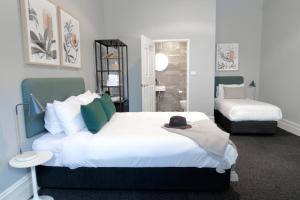 a bedroom with a large bed with a hat on it at The Alison Randwick in Sydney