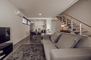 uma sala de estar com um sofá e uma escada em 9 Furnas Villa em Furnas