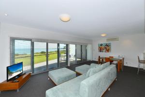 a living room with a couch and a flat screen tv at Sea Side Villa 10.1 in Mandurah