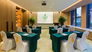 a conference room with green tables and white chairs at Holiday Inn Nanjing Qinhuai South Suites by IHG in Jiangning