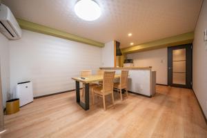 a dining room with a table and chairs in a room at Residence Hotel Takayama Station in Takayama