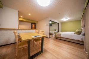 a room with a bed and a table and a bedroom at Residence Hotel Takayama Station in Takayama +39 photos