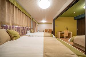 a hotel room with two beds and a desk at Residence Hotel Takayama Station in Takayama