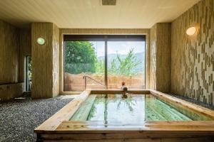 uma banheira de hidromassagem num quarto com uma grande janela em Apolosou em Yugawara