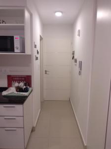 una cocina con armarios blancos y un pasillo con puerta en Ejecutivo, en Bahía Blanca