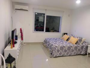 un dormitorio con una cama y una ventana en Ejecutivo, en Bahía Blanca