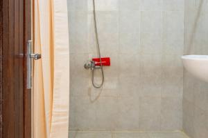y baño con ducha de color rojo. en RedDoorz Plus near Balai Kota Batu 2, en Malang
