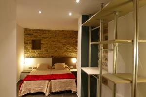 a bedroom with a bed and a brick wall at La Solana de Jaca - Casa Collarada in Novés