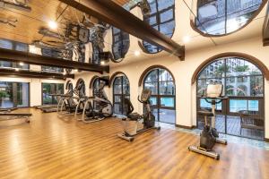 a gym with treadmills and ellipticals in a room with windows at La casita Hua-Hin seaview by Yaya in Hua Hin