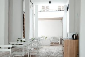 a white room with white tables and chairs at Bobopod Kota Lama, Semarang in Semarang