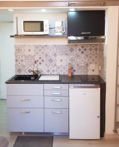a kitchen with white cabinets and a microwave at Studio au Coeur de Marseille in Marseille