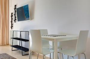 a white dining room table with two white chairs at Villa Katarina Dubrovnik in Dubrovnik