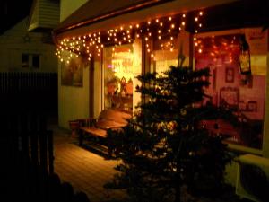 a porch with a christmas tree and lights at Willa Pod Jedlicą in Ciechocinek