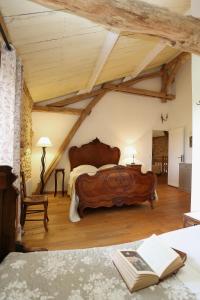 a bedroom with two large wooden beds in a room at Chambres d'Hôtes Léone Haute in Saint-Avit-Rivière