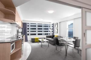 een keuken en woonkamer met een bank en een tafel bij Mantra on Kent in Sydney