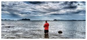 a man standing in the water holding a fishing pole at 8IK88 Resort, Phuket - SHA Extra Plus in Por Bay +120 photos