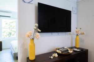 dos jarrones amarillos con flores en una mesa en una habitación en Lotus Stay Manly - Apartment 31F, en Sídney