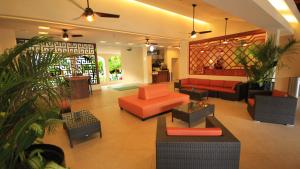 a lobby with orange furniture and plants in a building at Holiday Inn Huatulco, an IHG Hotel in Santa Cruz Huatulco