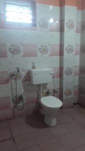 a bathroom with a white toilet in a room at Pandeys Homestay Kalimpong in Kalimpong