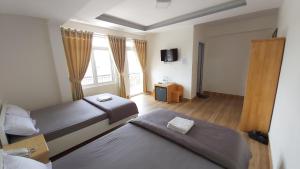 a hotel room with two beds and a television at Duy Hotel in Da Lat