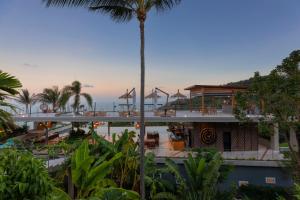 a view of a building with a palm tree at Kapuhala Koh Samui- Vegan Boutique Hotel in Chaweng Noi Beach